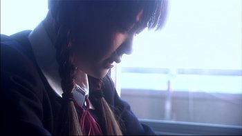 Movie still from “All About Lily Chou-Chou” (2001), directed by Shunji Iwai – A young girl with braids looking out a window; Close Up shot, Low angle