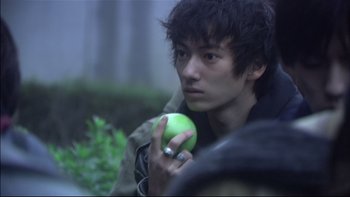 Movie still from “All About Lily Chou-Chou” (2001), directed by Shunji Iwai – A man holding an apple in his hand; Close Up shot, Over the shoulder angle