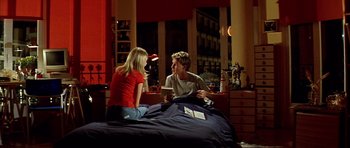 Movie still from “All About My Mother” (1999), directed by Pedro Almodóvar – A man and a woman sitting on top of a bed talking; Wide shot, High angle