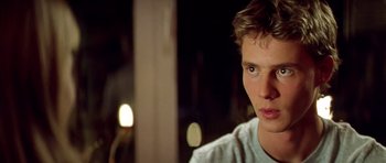 Movie still from “All About My Mother” (1999), directed by Pedro Almodóvar – A young man's face with lights in the background; Close Up shot, Over the shoulder angle
