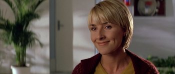 Movie still from “All About My Mother” (1999), directed by Pedro Almodóvar – A person with short blonde hair; Close Up shot, Over the shoulder angle