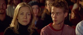 Movie still from “All About My Mother” (1999), directed by Pedro Almodóvar – A woman and a man sitting next to each other in a crowd; Close Up shot, Low angle