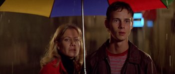 Movie still from “All About My Mother” (1999), directed by Pedro Almodóvar – A man and a woman standing next to each other holding an umbrella; Close Up shot, Low angle