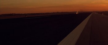 Movie still from “All About My Mother” (1999), directed by Pedro Almodóvar – The sun is setting over a runway and a field; Extreme Wide shot, Low angle