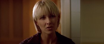 Movie still from “All About My Mother” (1999), directed by Pedro Almodóvar – A person with short blonde hair; Close Up shot, Over the shoulder angle