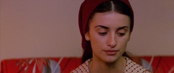 Movie still from “All About My Mother” (1999), directed by Pedro Almodóvar – A woman with a head scarf is sitting down; Close Up shot, Over the shoulder angle