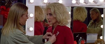 Movie still from “All About My Mother” (1999), directed by Pedro Almodóvar – A woman putting a brooch on a person's lapel; Close Up shot, Over the shoulder angle