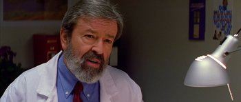 Movie still from “All About My Mother” (1999), directed by Pedro Almodóvar – An older man wearing a white lab coat and a red tie; Close Up shot, Low angle
