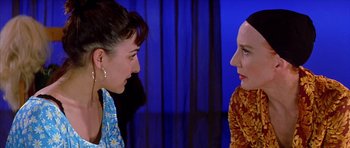 Movie still from “All About My Mother” (1999), directed by Pedro Almodóvar – Two women talking to each other in front of a blue curtain; Close Up shot, Over the shoulder angle