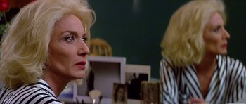Movie still from “All About My Mother” (1999), directed by Pedro Almodóvar – A woman looking at herself in the mirror; Close Up shot, Over the shoulder angle