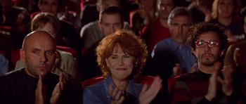 Movie still from “All About My Mother” (1999), directed by Pedro Almodóvar – A woman clapping while sitting in an audience; Close Up shot, High angle