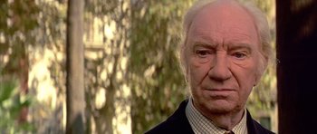 Movie still from “All About My Mother” (1999), directed by Pedro Almodóvar – An old man with a white beard is looking at the camera; Close Up shot, Low angle