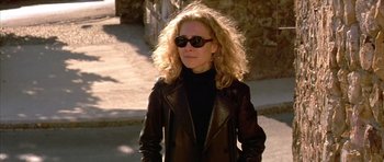 Movie still from “All About My Mother” (1999), directed by Pedro Almodóvar – A woman wearing sunglasses and a leather jacket; Medium shot, Low angle