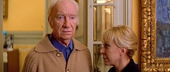 Movie still from “All About My Mother” (1999), directed by Pedro Almodóvar – An older man and a younger woman standing next to each other in front of a door; Close Up shot, Over the shoulder angle