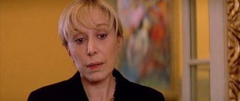 Movie still from “All About My Mother” (1999), directed by Pedro Almodóvar – A person wearing a suit and tie; Close Up shot, Over the shoulder angle