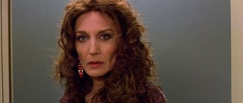 Movie still from “All About My Mother” (1999), directed by Pedro Almodóvar – A person with long curly hair; Close Up shot, Over the shoulder angle