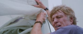 Movie still from “All Is Lost” (2013), directed by J.C. Chandor – An older man is pulling a sheet off of a bed; Close Up shot, Low angle