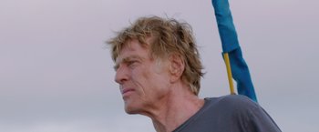 Movie still from “All Is Lost” (2013), directed by J.C. Chandor – A person wearing a gray t - shirt; Close Up shot, Low angle