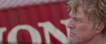 Movie still from “All Is Lost” (2013), directed by J.C. Chandor – A person's face in front of a red background; Close Up shot, Low angle