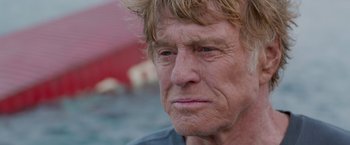 Movie still from “All Is Lost” (2013), directed by J.C. Chandor – An older man with blonde long hair and blue eyes; Close Up shot, Over the shoulder angle