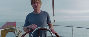 Movie still from “All Is Lost” (2013), directed by J.C. Chandor – A man steering a boat on the water; Medium shot, Low angle