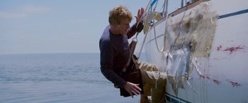 Movie still from “All Is Lost” (2013), directed by J.C. Chandor – A man climbing up the side of a sailboat; Medium shot, Low angle