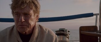 Movie still from “All Is Lost” (2013), directed by J.C. Chandor – An older man is sitting on the deck of a boat; Close Up shot, Over the shoulder angle