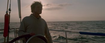 Movie still from “All Is Lost” (2013), directed by J.C. Chandor – A man standing on the deck of a boat in the ocean; Medium shot, Low angle