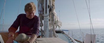 Movie still from “All Is Lost” (2013), directed by J.C. Chandor – A man sitting on a boat in the water; Medium shot, Low angle