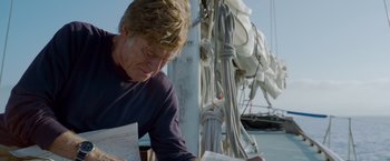 Movie still from “All Is Lost” (2013), directed by J.C. Chandor – A man sitting at a table on a boat; Close Up shot, Low angle