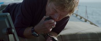 Movie still from “All Is Lost” (2013), directed by J.C. Chandor – A man is talking on a cell phone while lying on the ground; Close Up shot, Low angle
