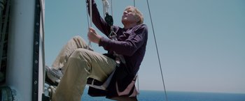 Movie still from “All Is Lost” (2013), directed by J.C. Chandor – A man hanging from a rope on a sail boat in the ocean; Medium shot, Low angle