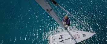 Movie still from “All Is Lost” (2013), directed by J.C. Chandor – A person on a sail boat in the water; Extreme Wide shot, Overhead angle