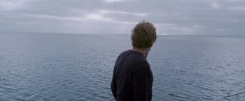 Movie still from “All Is Lost” (2013), directed by J.C. Chandor – A man standing in front of a body of water; Medium shot, High angle