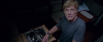 Movie still from “All Is Lost” (2013), directed by J.C. Chandor – A man in a kitchen with a sink and a stove; Medium shot, Low angle