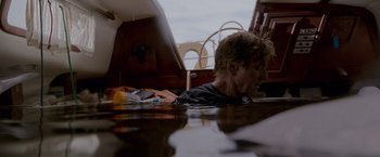 Movie still from “All Is Lost” (2013), directed by J.C. Chandor – A man laying on a boat in the water; Medium shot, Low angle