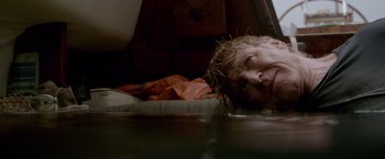 Movie still from “All Is Lost” (2013), directed by J.C. Chandor – A man laying on the ground in a room; Close Up shot, Low angle
