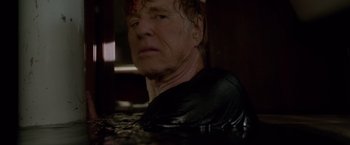 Movie still from “All Is Lost” (2013), directed by J.C. Chandor – An older man in a black shirt in a pool of water; Close Up shot, Low angle