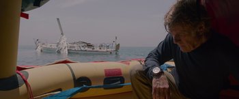 Movie still from “All Is Lost” (2013), directed by J.C. Chandor – A man sitting on a raft in the water; Medium shot, Low angle