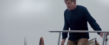 Movie still from “All Is Lost” (2013), directed by J.C. Chandor – An older man standing next to a boat in the water; Medium shot, Low angle