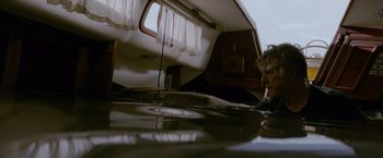 Movie still from “All Is Lost” (2013), directed by J.C. Chandor – A man sitting on a boat in the middle of the water; Wide shot, Low angle