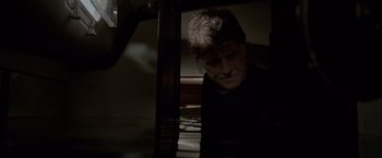 Movie still from “All Is Lost” (2013), directed by J.C. Chandor – A man sitting in a chair in a dark room; Medium shot, High angle