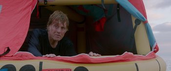 Movie still from “All Is Lost” (2013), directed by J.C. Chandor – A man leaning on the side of a boat; Medium shot, Low angle