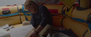 Movie still from “All Is Lost” (2013), directed by J.C. Chandor – A man sitting on the ground in a room; Medium shot, High angle