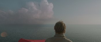 Movie still from “All Is Lost” (2013), directed by J.C. Chandor – A man looking out over the ocean at a cloudy sky; Medium shot, Low angle
