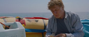 Movie still from “All Is Lost” (2013), directed by J.C. Chandor – An older woman sitting on a boat eating a sandwich; Close Up shot, Low angle