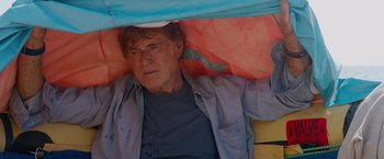 Movie still from “All Is Lost” (2013), directed by J.C. Chandor – A person laying on the ground under a blanket; Close Up shot, Low angle