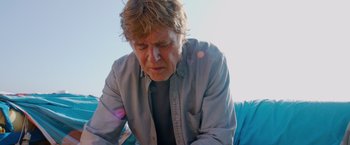 Movie still from “All Is Lost” (2013), directed by J.C. Chandor – An older man sitting on top of a blue chair; Close Up shot, Low angle