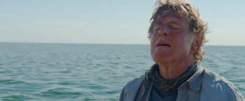 Movie still from “All Is Lost” (2013), directed by J.C. Chandor – An older man with his eyes closed near the ocean; Close Up shot, Low angle