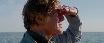 Movie still from “All Is Lost” (2013), directed by J.C. Chandor – An older man looking into the distance with a hand on his forehead; Close Up shot, Low angle